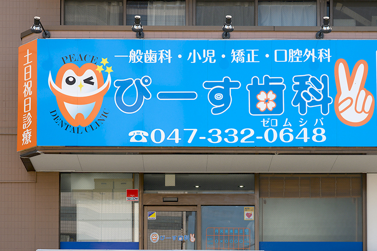 ぴーす歯科 船橋市 かわいらしい歯のキャラクターとピースサインの看板が目印