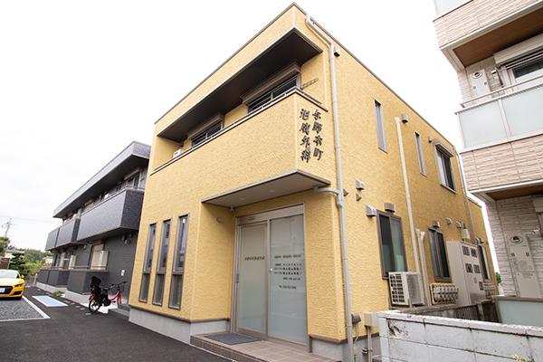 優しい黄色の外観が目印。落ち着いた住宅街に位置する形成外科 1