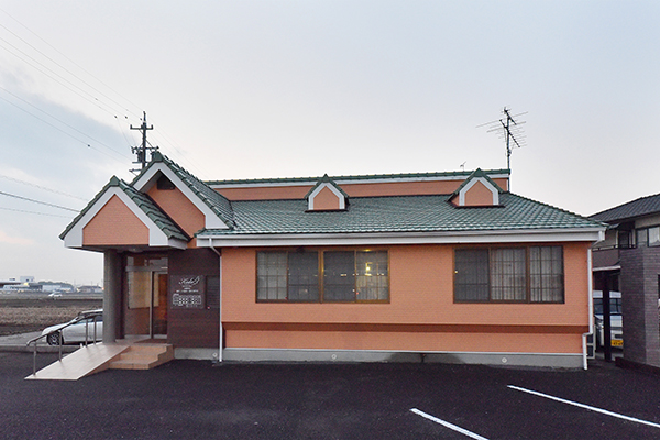 温かみのあるオレンジ色の外観が印象的な歯科医院 1