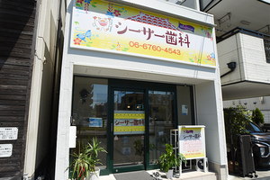 シーサー歯科 大阪市大正区 シーサーのロゴマークが描かれた沖縄らしさが伝わる外観