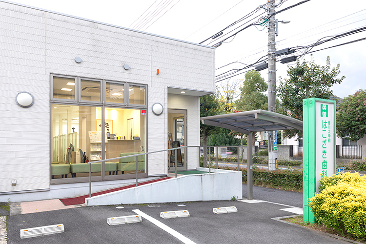 香川大学前はこざき歯科医院 高松市 緑色のロードサインが目印の、白い外観