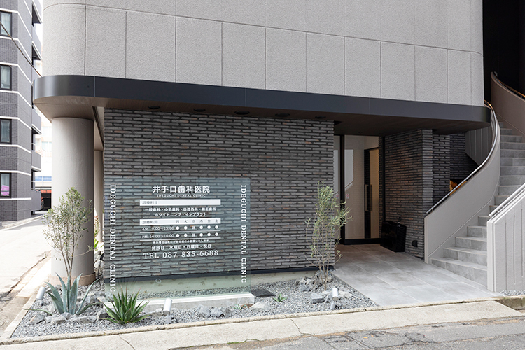 井手口歯科医院 高松市 グレー調のモダンな外観に植物の緑が映える