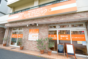 医療法人社団あかし会 山村クリニック 文京区 クリニック外観。鮮やかなオレンジの看板が目印