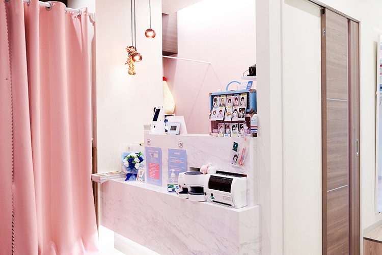 アキバ歯科 千代田区 白とピンクを基調とした、やわらかな色合いの受付