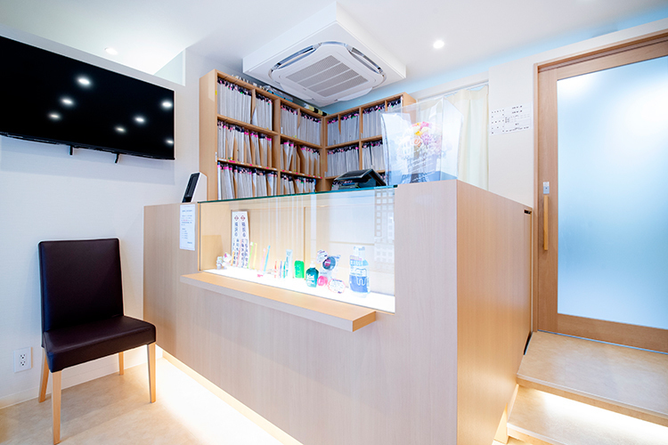 河野歯科医院 横浜市都筑区 すっきりと整理された受付。明るい笑顔で患者を出迎えている