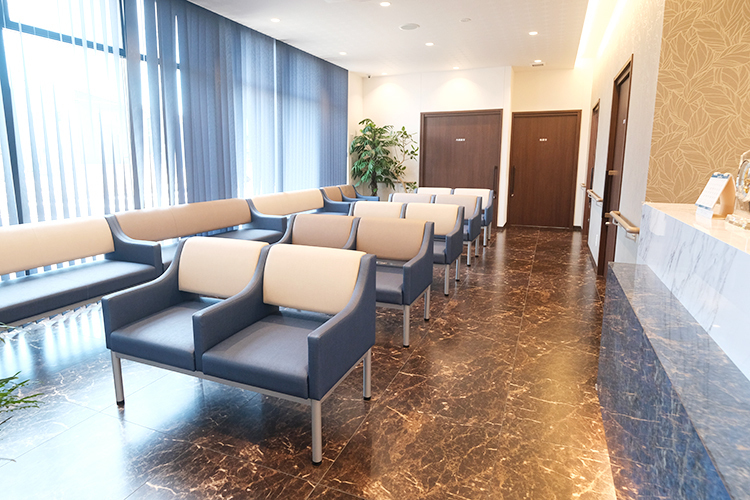 かわい泌尿器・腎臓内科クリニック みよし市 落ち着いた色合いの床と椅子が心を和ませる上品な待合スペース