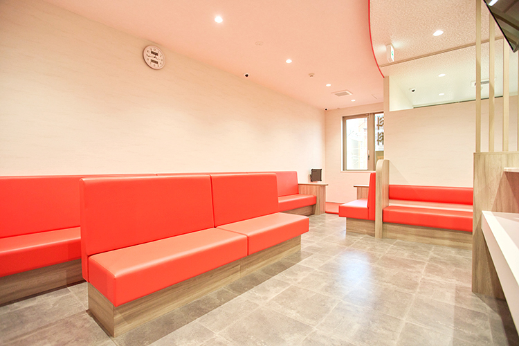 さえき耳鼻咽喉科 分院 明石市 ビビッドなオレンジのソファーが印象的な明るく広い待合室