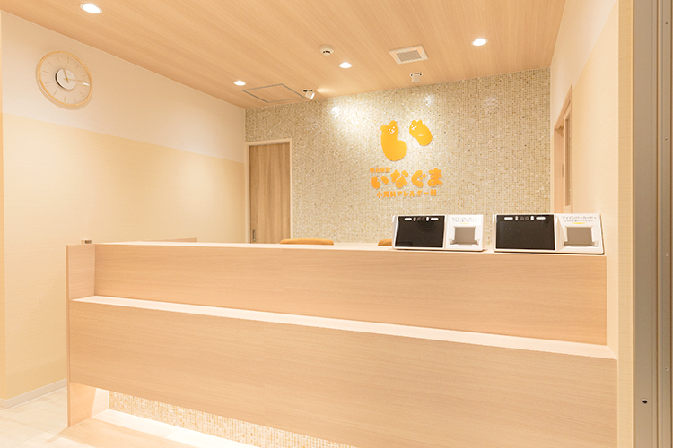 明石駅前いなぐま小児科アレルギー科 明石市 オレンジのロゴが目を引く、木の温かみを感じる受付