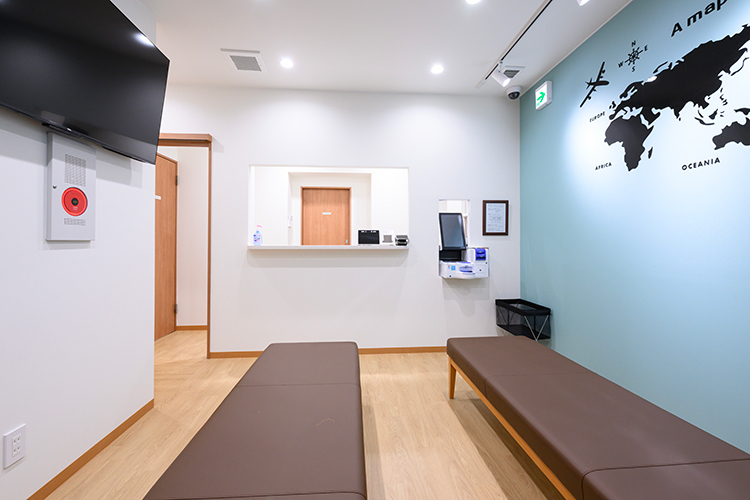 KNなんばインターナショナルクリニック 大阪市浪速区 壁紙の世界地図が目を引く、広々とした待合スペース