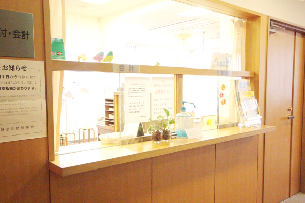 石井耳鼻咽喉科診療所 横浜市中区 受付ではスタッフが笑顔で患者を迎えている