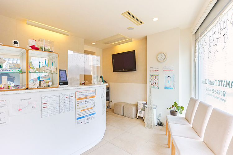 やまとデンタルクリニック 向日市 白を基調とした明るい雰囲気の院内。スタッフが笑顔で出迎える