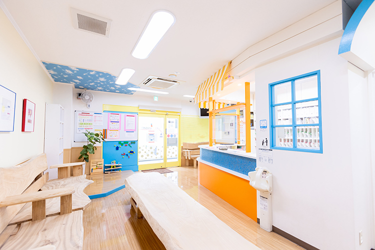 いわや小児科クリニック 福岡市西区 ヒノキの椅子が並ぶ院内。スタッフが笑顔で迎えてくれる