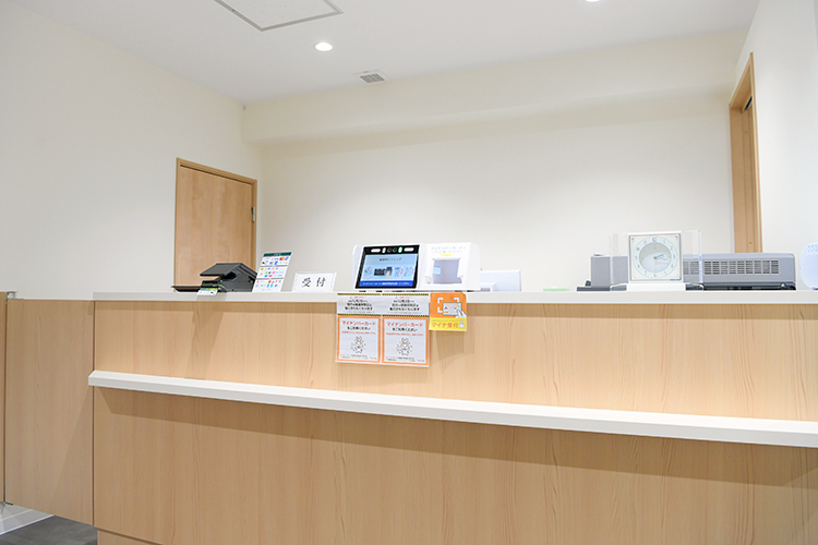 聖堂前クリニック 千代田区 木目調の受付カウンター。マイナンバー受付機器なども備える