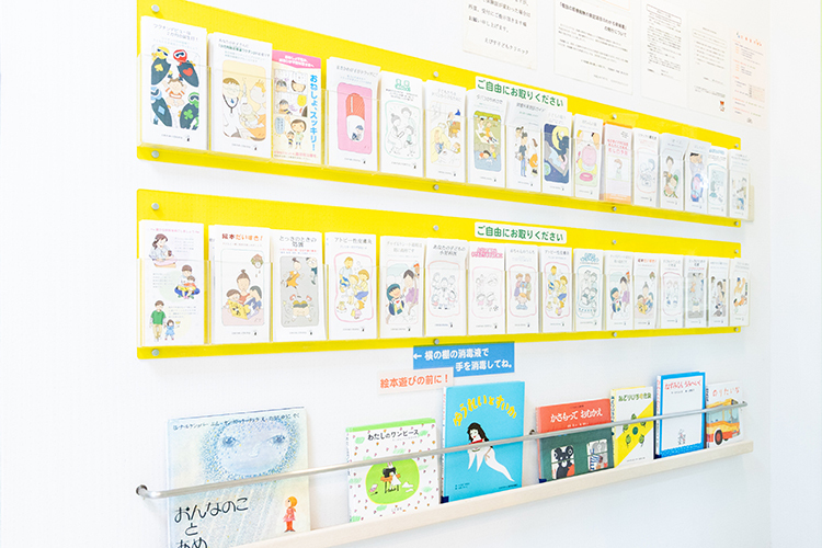 えびす子どもクリニック 北九州市小倉北区 待合室の壁にはさまざまなリーフレットと絵本が並んでいる