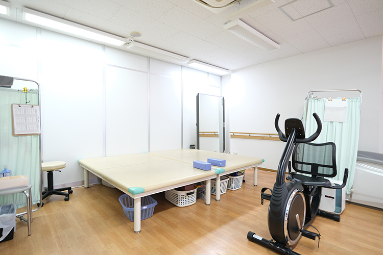 こうなんクリニック 板橋区 リハビリテーション用の訓練台やトレーニング機器を備えた処置室