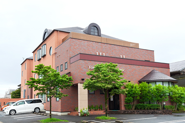 とまつレディースクリニック 可児市 外観。幅広い駐車場を完備