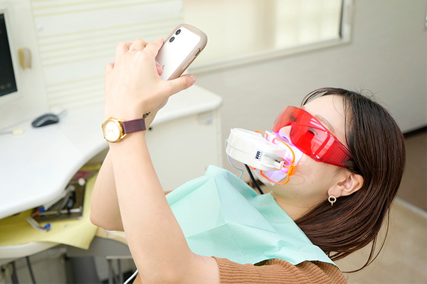 高野デンタルクリニック 口に乗せるタイプの光照射器で施術をスタート