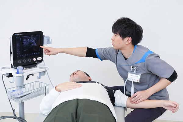 かのう整形外科 リハビリスタッフが患者と体を動かしながら説明