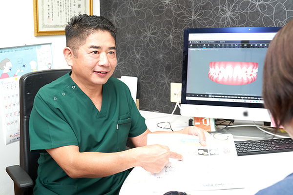上田歯科医院 資料を用いて丁寧な説明を行う上田院長